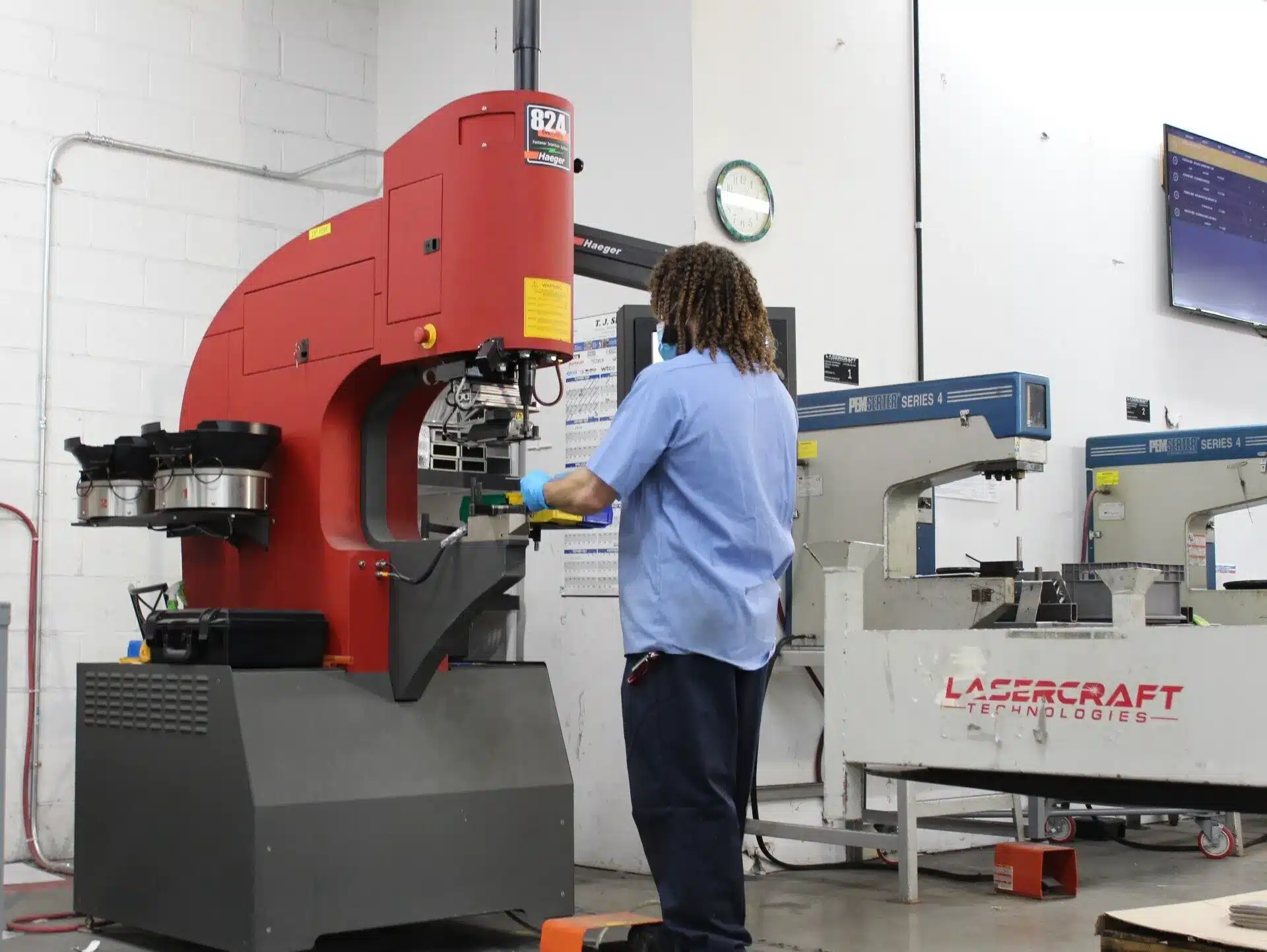 Worker operating a piece of machinery in a workshop.