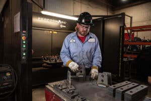 Laser Craft Tech employee making steel brackets