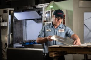 Laser Craft Tech employee inspects a recently fabricated piece of metal