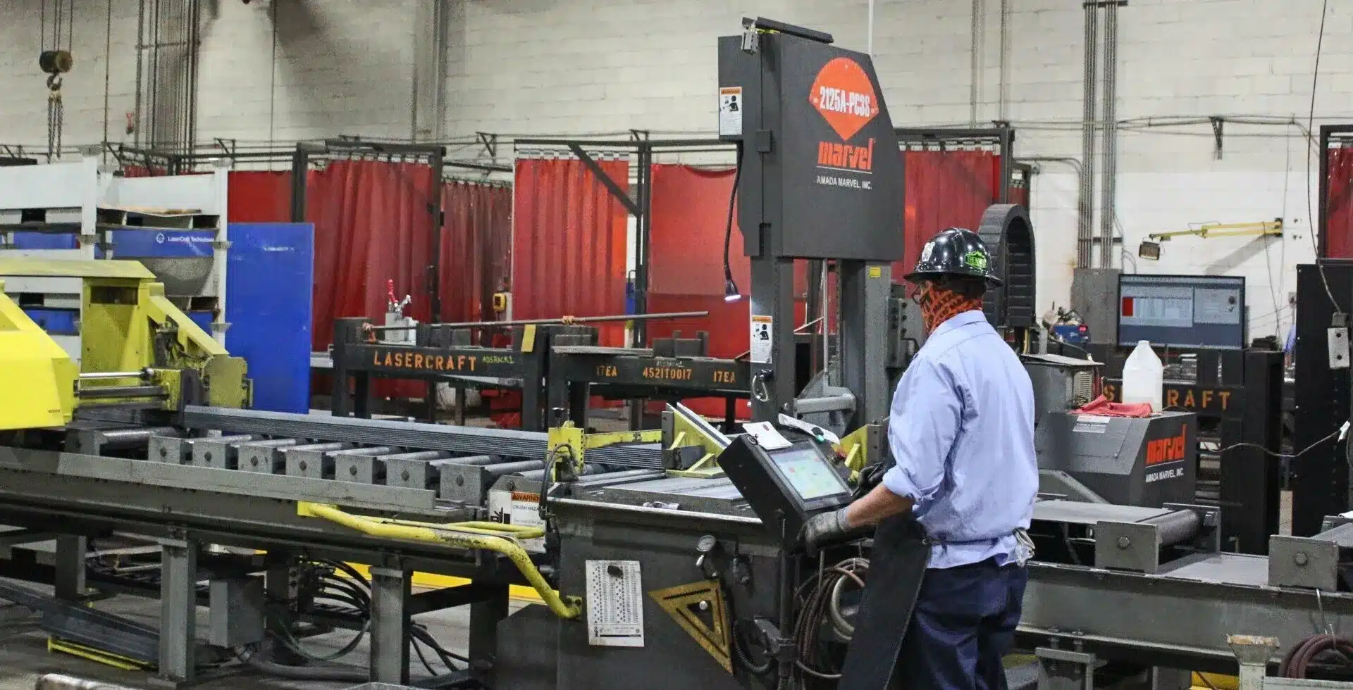 Laser Craft Tech employee using a band saw in a shop