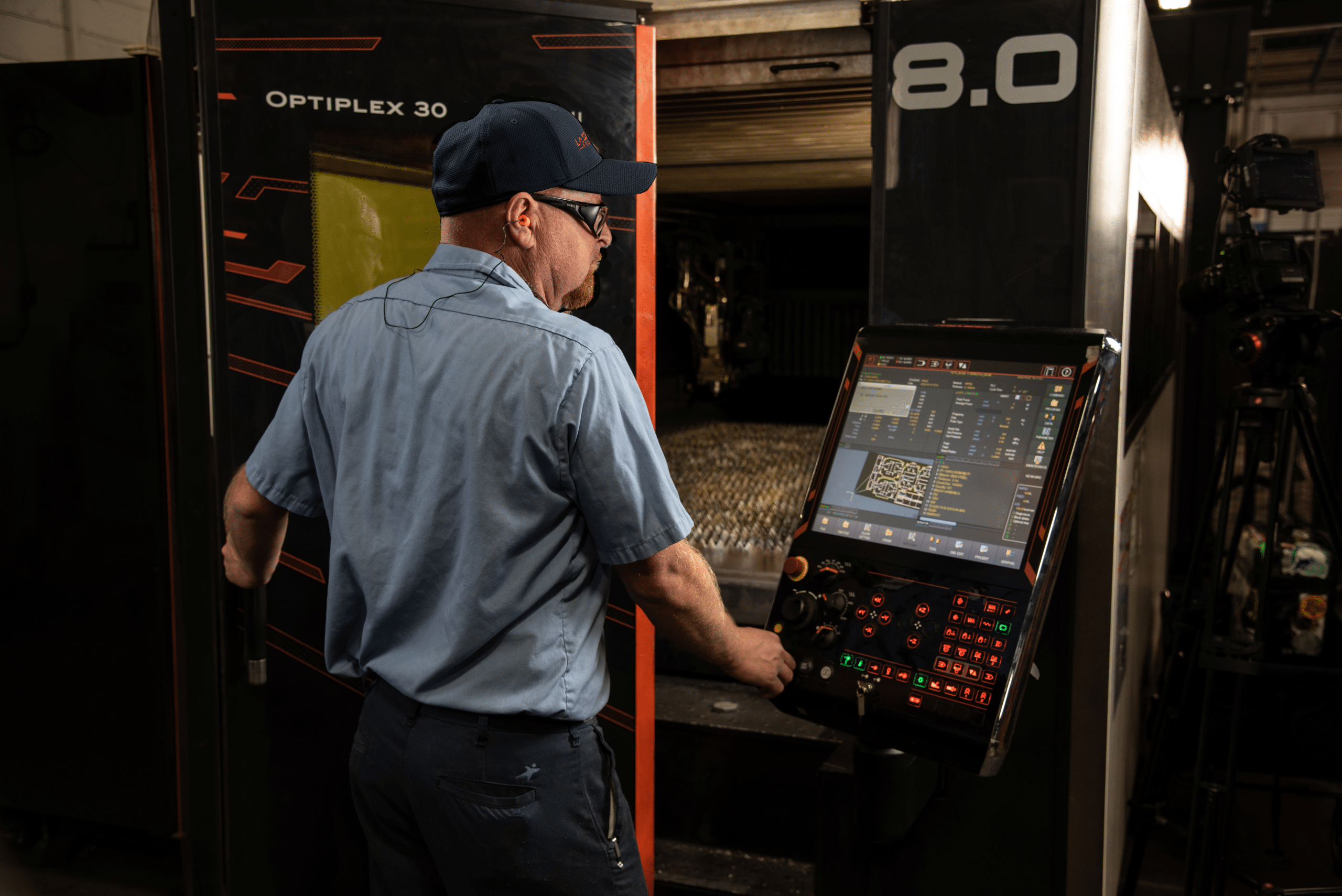 Laser Craft Tech employee interacts with a machines control panel